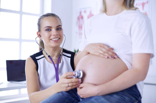 Giovane medico donna esaminando donna incinta presso la clinica. - Foto, immagini