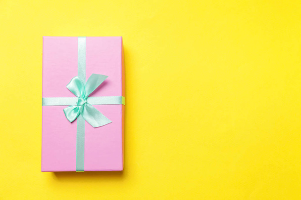 Weihnachten Silvester Geburtstag valentine Feier präsentieren romantisches Konzept. rosa Geschenkbox isoliert auf gelbem Hintergrund - Foto, Bild