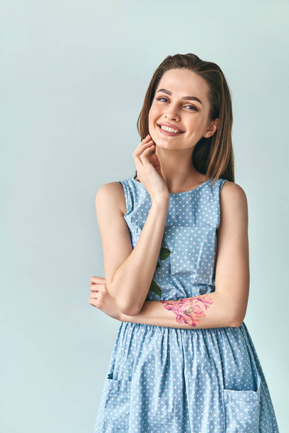 Happy smiling beautiful woman in polka dot dress posing in studio looking to camera. Beauty concept                                 - Foto, imagen