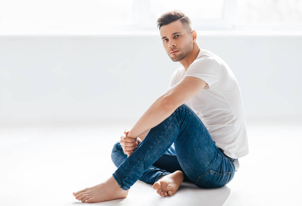 Thoughtful handsome man portrait sitting on floor. Male beauty concept - Foto, immagini