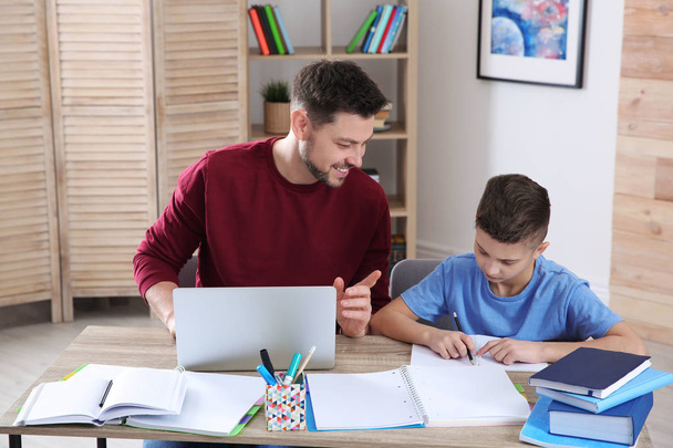 Dad helping his son with homework in room - Foto, Bild
