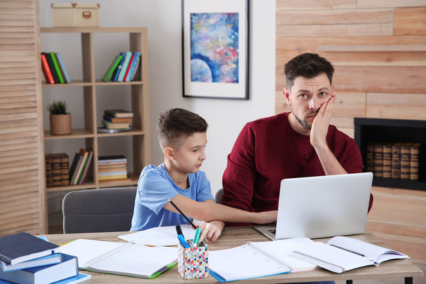 Dad helping his son with difficult homework assignment in room, space for text - Photo, Image