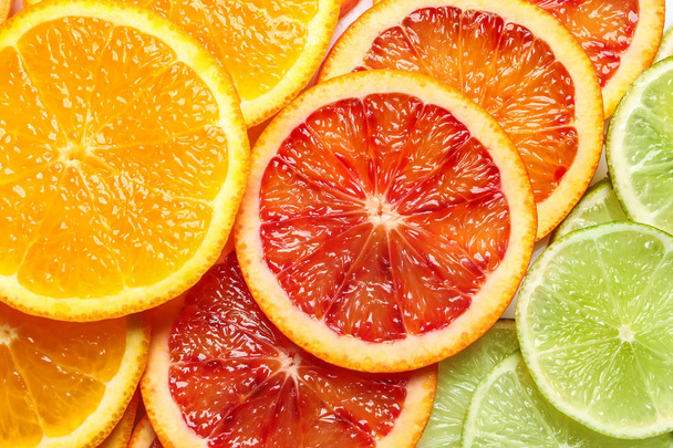 Slices of fresh citrus fruits as background, top view - Foto, Imagen
