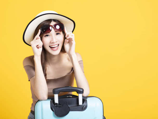 γυναίκα ευτυχισμένη τουριστικά στο καλοκαίρι καπέλο, γυαλιά ηλίου και suitca κτήσης - Φωτογραφία, εικόνα