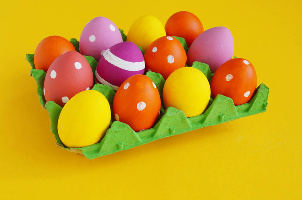 Easter eggs in a tray for eggs a stand. Yellow background. - Foto, Bild