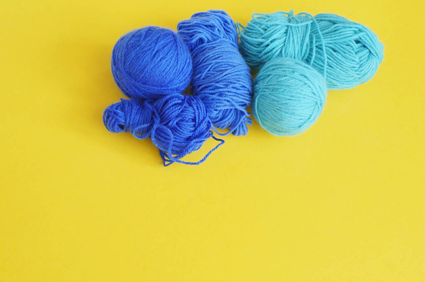 Blue ball of woollen thread. Threads, wool, blue and turquoise colors with a pair of scissors. - Zdjęcie, obraz
