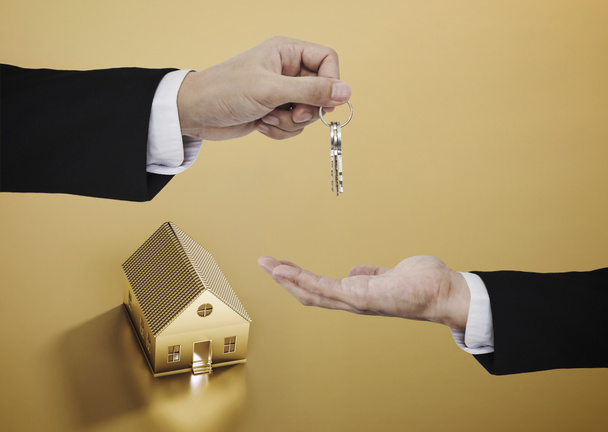 Real estate business, residential rental and investment. Businessman handover key with golden house background - Photo, Image