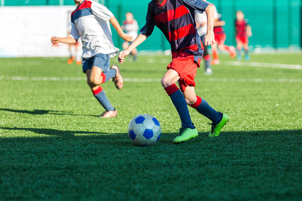 Jalkapallo koulutus jalkapallo lapsille. Poika juoksee potkujen kanssa. Nuoret jalkapalloilijat tihkuvat ja potkivat palloa peliin. Koulutus, aktiivinen elämäntapa, urheilu, lasten toiminta käsite
 - Valokuva, kuva