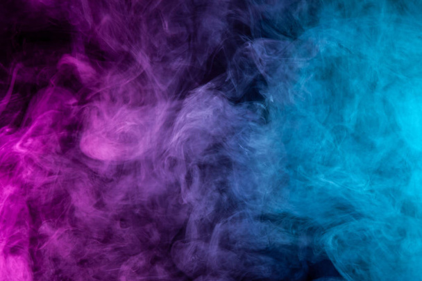 Заморожений абстрактний рух вибуху рожевого і синього диму декількох кольорів на чорному тлі. Тло з диму пари
 - Фото, зображення