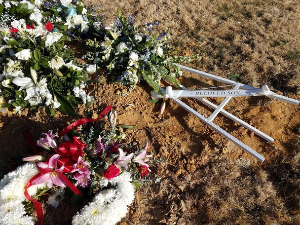 πέσει ο αγαπημένος Υιός σημάδι στο χώμα με λουλούδια στο νεκροταφείο - Φωτογραφία, εικόνα