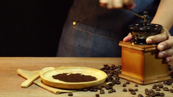 Dolly women's hands are grinding coffee beans on a wooden table. - Materiaali, video