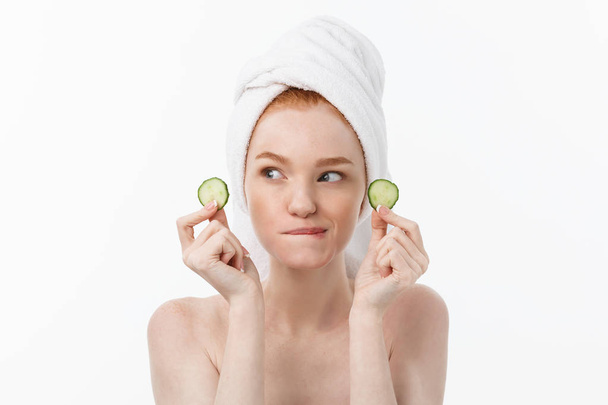 Attractive Young Woman with beautiful clean skin. White mask and cucumbers. Beauty treatments and cosmetology spa therapy. White background - Foto, Imagen
