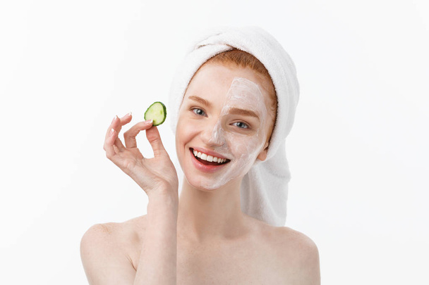 Güzel temiz cilt çekici genç kadın. Beyaz maske ve salatalık. Güzellik bakımı ve kozmetik spa terapisi. Beyaz arka plan - Fotoğraf, Görsel