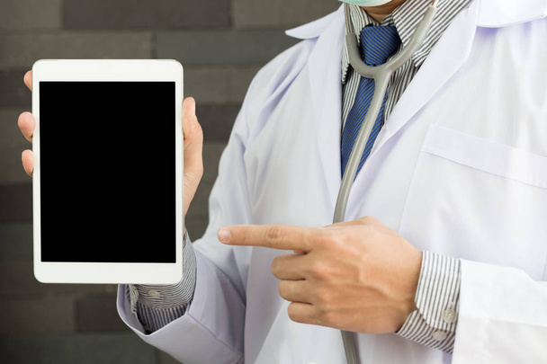 Primer plano de un médico varón con bata de laboratorio y tableta de retención para ofrecer aplicaciones médicas
 - Foto, imagen