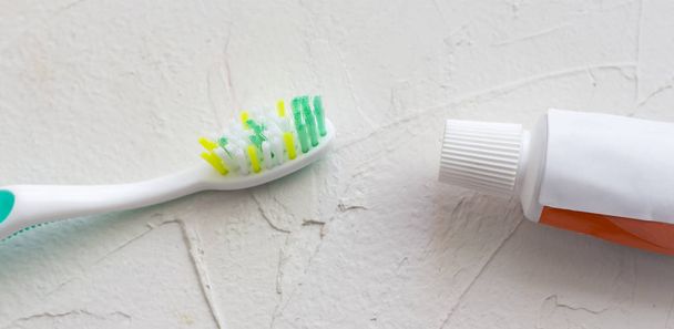 cepillo de dientes y pasta de dientes sobre fondo texturizado blanco
 - Foto, Imagen