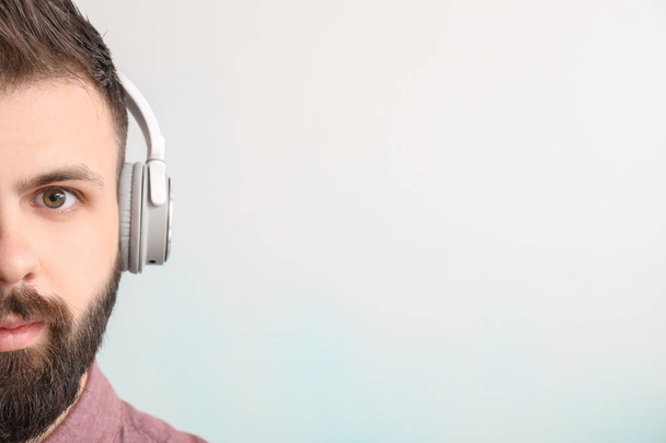 Handsome young man listening to music on white background - Photo, Image