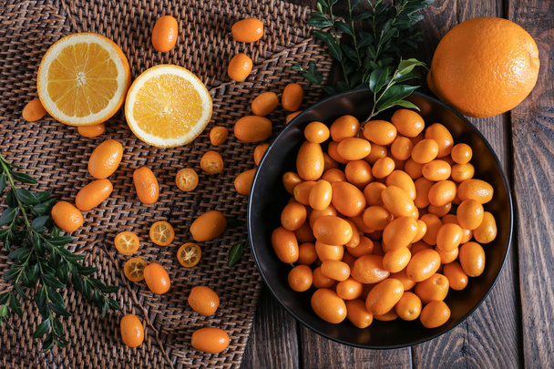 Composition with delicious kumquat fruit on table - Fotó, kép