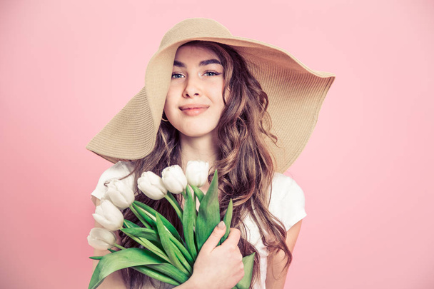 dívka v klobouku a tulipány na barevném pozadí - Fotografie, Obrázek
