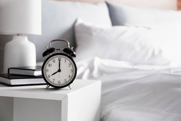 Alarm klok op tafel in de slaapkamer - Foto, afbeelding