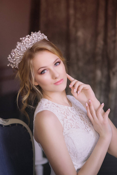 Young beautiful bride with blond hair in a diadem and white veil and white dress - 写真・画像