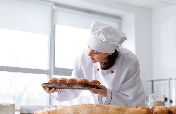 Chef femelle avec pâtisserie fraîchement cuite dans la cuisine
 - Photo, image