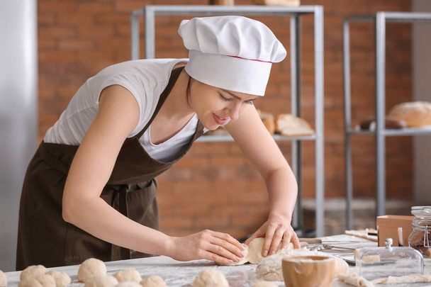 Panecillos de cocina de panadero femenino en la cocina
 - Foto, Imagen