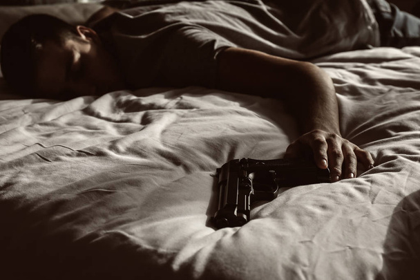Mies aseen kanssa tehtyään itsemurhan makuuhuoneessa
 - Valokuva, kuva