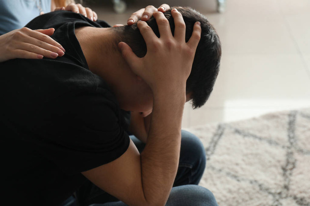 Vrouw kalmerende depressief mannelijke suicider thuis - Foto, afbeelding