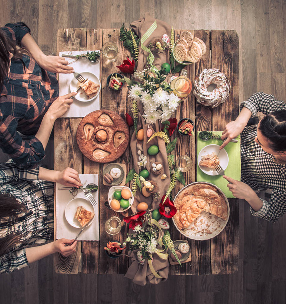 Apartment-feast of friends or family at the festive table with rabbit meat, vegetables, pies, eggs, top view. - Photo, Image