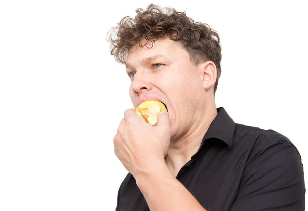 un hombre comiendo una manzana sobre un fondo blanco
 - Foto, Imagen