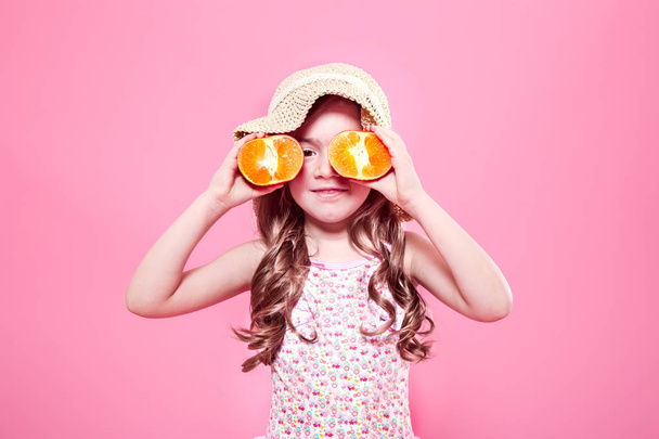 Śmieszne, mała dziewczynka z owoców cytrusowych na kolor tła - Zdjęcie, obraz