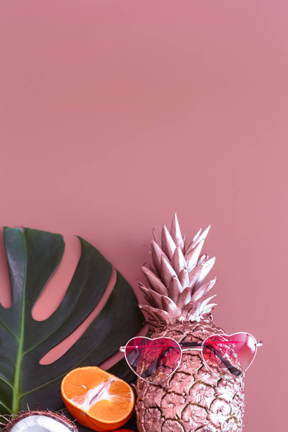 Abacaxi com folha tropical e óculos em um fundo colorido. conceito tropical de verão
 - Foto, Imagem