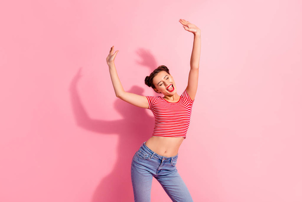 Portrait of her she nice cute attractive glamorous winsome cheerful cheery girl wearing striped t-shirt jeans raising hands up having fun isolated over pink pastel background - Foto, imagen