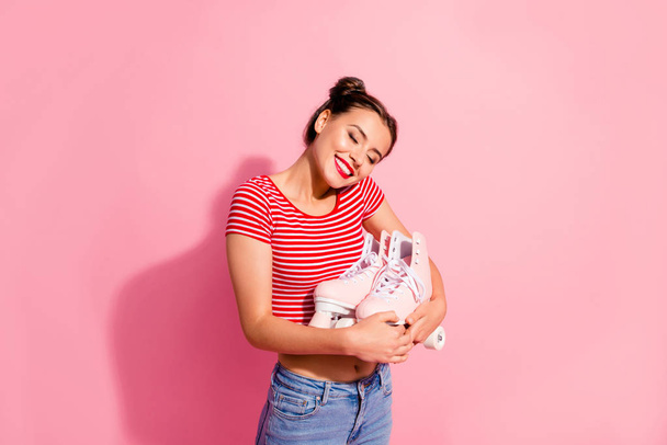 Portrait of her she nice-looking cute charming attractive lovely winsome cheerful girl wearing striped t-shirt holding in hands hugging new cool roll skates isolated on pink pastel background - Foto, imagen