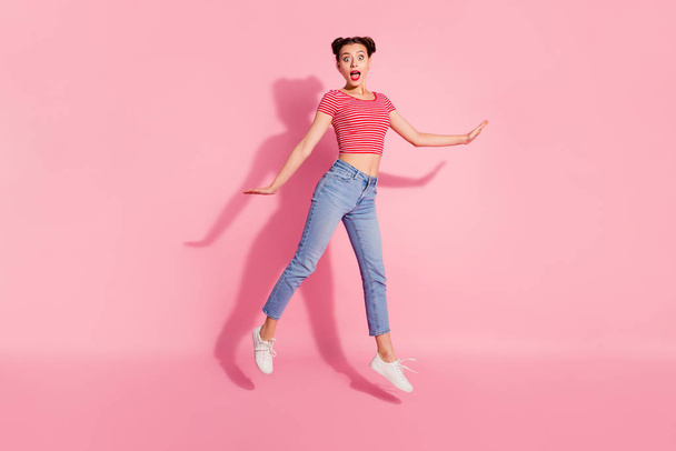 Full length body size photo beautiful she her lady pomade lips jump high ecstatic astonished low prices shopping wear casual jeans denim striped red white t-shirt sit floor isolated pink background - Foto, afbeelding