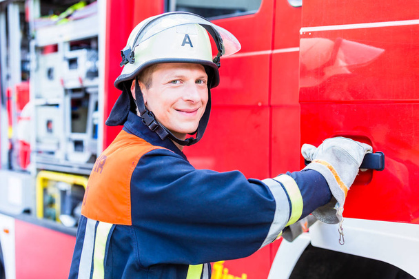 Feuerwehrmann steigt in Löschfahrzeug - Foto, Bild
