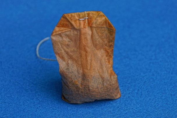viejo bolso de té usado marrón sobre fondo azul
 - Foto, Imagen