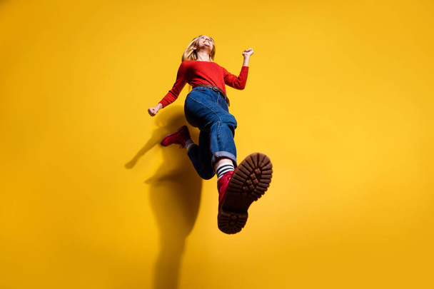 Low below angle full length body size view of nice attractive cheerful girl having fun going making step wearing vintage retro maroon boots isolated over bright vivid shine orange background - 写真・画像
