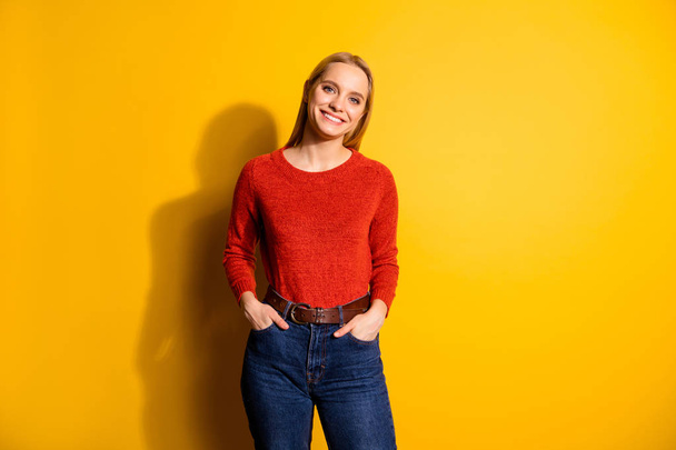 Portrait of her she nice-looking cute attractive lovely cheerful teen girl holding hands in pockets isolated over bright vivid shine orange background - Fotografie, Obrázek