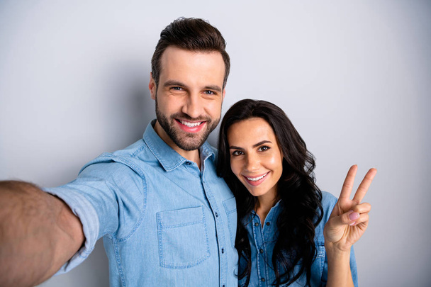 Close up portrait two amazing she her he him his couple lady guy couple make take selfies show v-sign say hi excited wear casual jeans denim shirts outfit clothes isolated light grey background - Foto, afbeelding