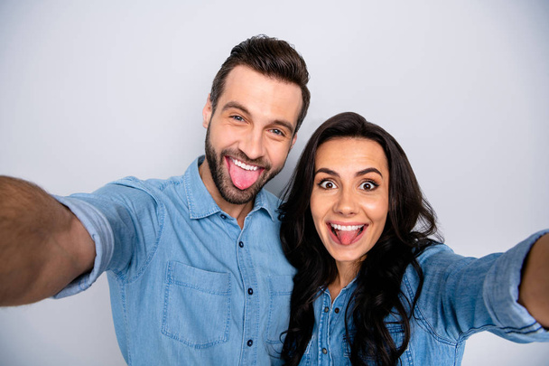 Close up portrait funky amazing she her he him his lady guy pretty couple make take selfies different facial expressions wear casual jeans denim shirts outfit clothes isolated light grey background - Fotografie, Obrázek