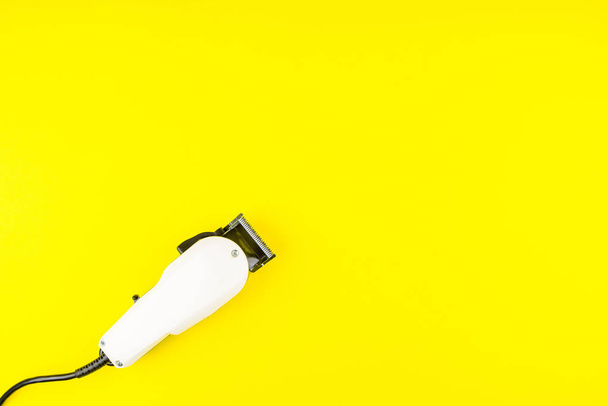 Белый электрические клипперы парикмахер на желтом фоне. Парикмахер
 - Фото, изображение
