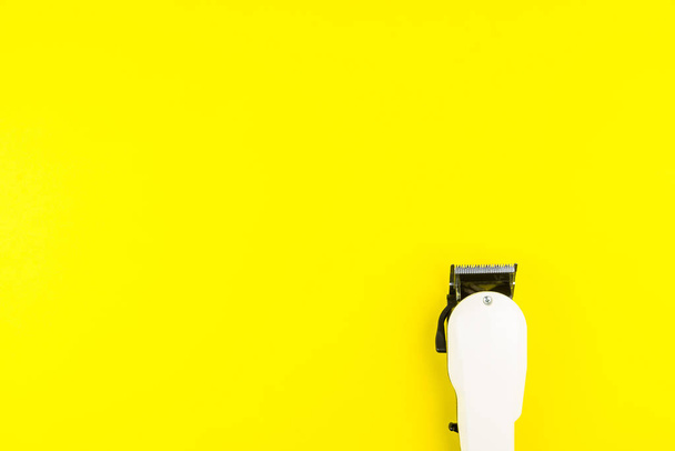 Fehér elektromos nyírógépek Borbély sárga háttéren. Fodrász - Fotó, kép