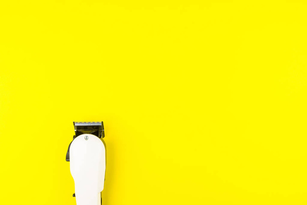 Cortadoras eléctricas blancas barbero sobre fondo amarillo. Peluquería
 - Foto, imagen