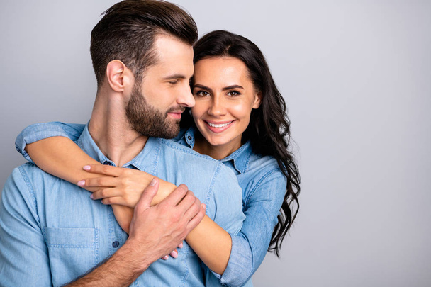 Love affair. Portrait of charming couple of millennial cheerful positive placing hands around chest wavy curly hair wearing blue denim shirts isolated on grey background  - Foto, Imagem