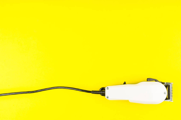 Valkoinen sähköleikkurit parturi keltaisella pohjalla. Kampaaja
 - Valokuva, kuva