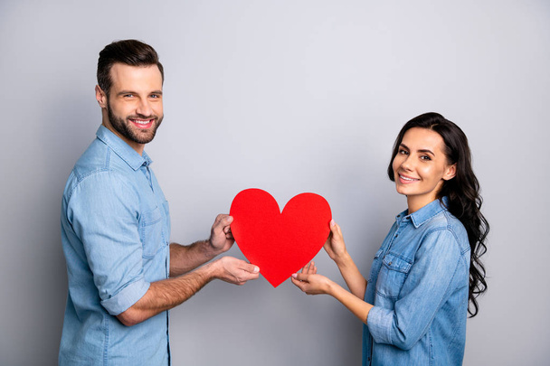 14-february Portrait of beautiful charming affectionate students showing regard respect trust support holding heart-shaped gifts presents isolated wearing blue jeans shirts on silver background - Foto, immagini
