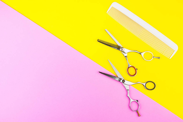 Stylish Professional Barber Scissors and comb on yellow and pink - Φωτογραφία, εικόνα