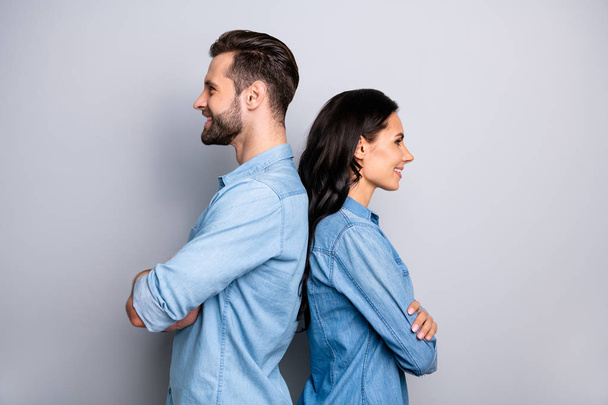 Back-to-back. Profile side view photo of cute pleasant nice workers fellows he she expressing teamwork collaboration trust dressed in blue denim shirts isolated on ashy-gray background - 写真・画像
