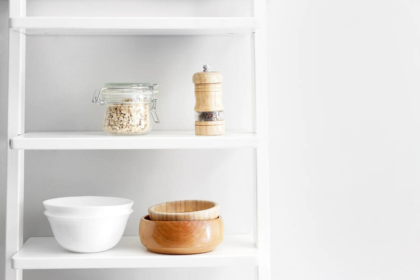 Shelves with kitchenware near white wall - Photo, Image
